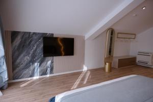 a bedroom with a bed and a tv on a wall at Villa 100 Boutique Pogradec in Pogradec +65 photos