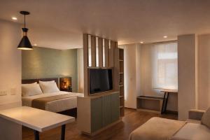 a hotel room with a bed and a television at Lago Verde Elit in Paipa