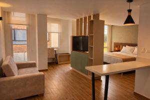 a hotel room with a bed and a tv at Lago Verde Elit in Paipa