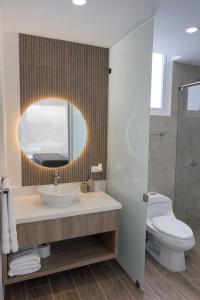 a bathroom with a sink and a toilet and a mirror at Lago Verde Elit in Paipa +7 photos