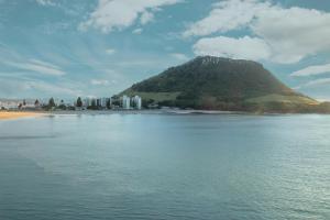 a mountain in the middle of a body of water at Miro St Guest House in Mount Maunganui +2 photos