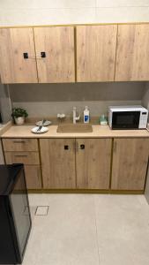 a kitchen with a sink and a microwave on a counter at AURA Stay in Dammam