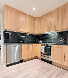 a kitchen with wooden cabinets and stainless steel appliances at Villa Storvoll - Fjord & Mountain View in Lyngen