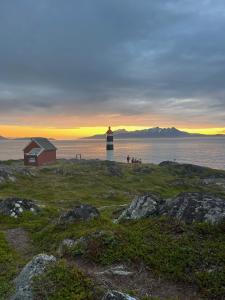 a lighthouse on the shore of a body of water at Villa Storvoll - Fjord & Mountain View in Lyngen