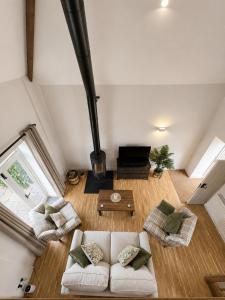 a living room with a white couch and a fireplace at The Raven Suites in Much Wenlock