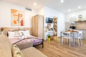 a living room with a bed and a kitchen at Deiana's House in Alghero