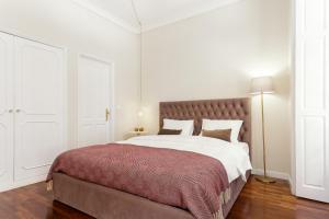 een witte slaapkamer met een groot bed met een rode deken bij Chateau Belomonte in Porto