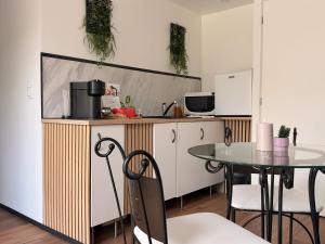 a kitchen with a table and a counter top at Le Bain des VioIettes - Grand jacuzzi privatif in Dole +10 photos