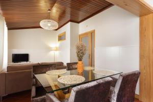a dining room with a table and chairs and a couch at Chateau Belomonte in Porto