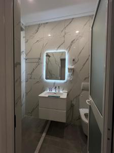 a bathroom with a sink and a mirror and a toilet at StayVibe in Krujë