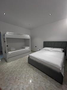 a bedroom with a large bed and a white wall at StayVibe in Krujë