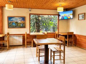a restaurant with tables and a tv on the wall at Hotel El Coihue in Pucón