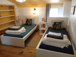 two beds in a small room with at Gîte de La Planette in La Romieu