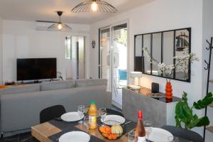a living room with a couch and a table at MAISON LEUCATINE - Classée 4 étoiles ! BBQ & Terrasse Privée - Climarisation & Parking privé - Séjour PROCHE PLAGE et IDEAL Famille - OFFRE SPECIALE - in Leucate-Plage
