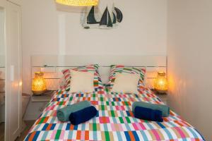 a bedroom with a colorful bed with two pillows at MAISON LEUCATINE - Classée 4 étoiles ! BBQ & Terrasse Privée - Climarisation & Parking privé - Séjour PROCHE PLAGE et IDEAL Famille - OFFRE SPECIALE - in Leucate-Plage
