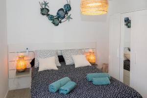 a bedroom with a bed with blue pillows on it at MAISON LEUCATINE - Classée 4 étoiles ! BBQ & Terrasse Privée - Climarisation & Parking privé - Séjour PROCHE PLAGE et IDEAL Famille - OFFRE SPECIALE - in Leucate-Plage