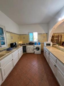 a large kitchen with a washer and dryer in it at Villa sedghiani in El Guecheïne