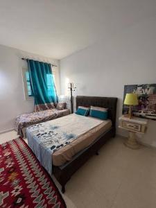 a bedroom with a bed and a couch and a table at Villa sedghiani in El Guecheïne +34 photos