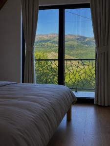 a bedroom with a bed and a large window at Villa Vasilije in Šavnik