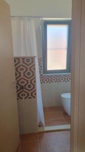 a bathroom with a toilet and a window at Piccolo Paradiso Crotone in Casa Margherita +5 photos