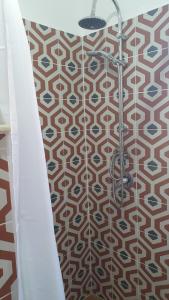 a shower in a bathroom with a patterned floor at Piccolo Paradiso Crotone in Casa Margherita