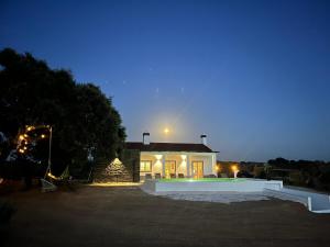 a house at night with the moon in the sky at Monte da Lebrinha in Vila Alva
