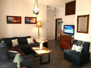 a living room with a couch and a tv at Billy's Place in Egina