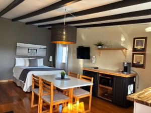 a bedroom with a bed and a table and chairs at Hôtel-Motel Vagues Vertes in Perce