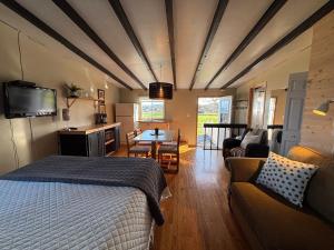 a bedroom with a bed and a living room at Hôtel-Motel Vagues Vertes in Perce