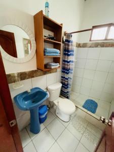 a bathroom with a blue sink and a toilet at PROMOCIOn VILLA PRIVADA SPRING in Puerto Ayora