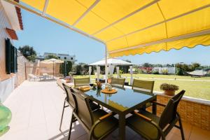 a table with chairs and a yellow umbrella on a patio at Mammacaterina - Procida in Procida +74 photos