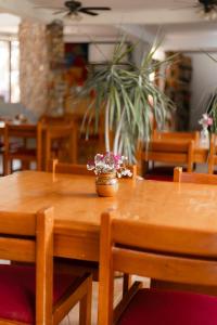 a wooden table with a vase of flowers on it at Casa Gulal in Teotitlán del Valle
