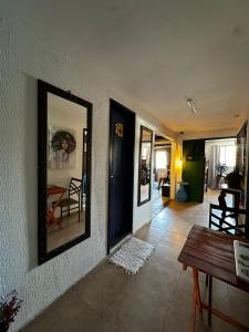 a living room with a table and a mirror at Amorim's Family Hostel in Olinda