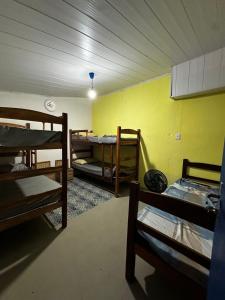 a room with three bunk beds and a yellow wall at Amorim's Family Hostel in Olinda