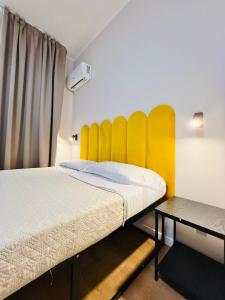 a bedroom with two beds and a yellow headboard at Porta Amari B&B in Palermo +77 photos