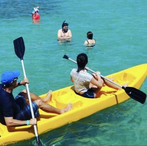 a group of people in a yellow kayak in the water at Amorim's Family Hostel in Olinda
