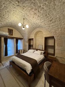 a bedroom with a large bed and a stone wall at Antikhan Han Yusufpaşa in Urfa