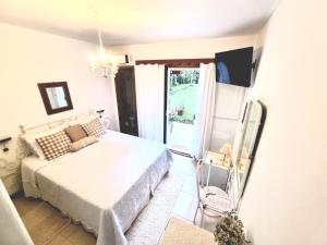 a bedroom with a bed and a sliding glass door at Pousada Boutique Rancho Campanário in Rancho Queimado