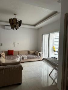 a living room with a couch and a large window at Zaineb in Hammamet Sud