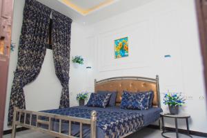 a bedroom with a bed with blue sheets and curtains at Mouhidiny Log Appart prestige in Dakan