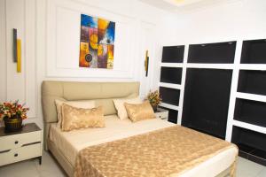 a bedroom with a bed and a painting on the wall at Mouhidiny Log Appart prestige in Dakan
