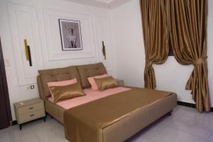 a bedroom with a large bed with two pillows at Mouhidiny Log Appart prestige in Dakan