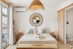 a bedroom with a bed and a mirror on the wall at Appart'hôtel DLOKOKO Sainte Luce centre in Sainte-Luce