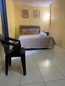 a bedroom with a bed and a chair and a chair at Hotel Oasis Beach Club in Puntarenas