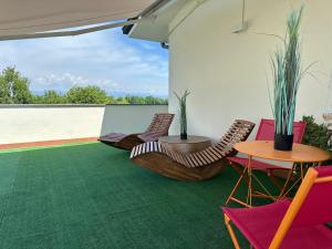 a patio with chairs and tables on a green carpet at The little lake Verona villa in Bovo