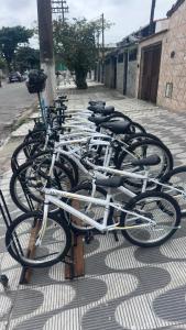 a row of bikes parked on a sidewalk at Moriah Hostel e Pousada in Praia Grande