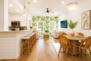 a kitchen and living room with a table and chairs at The Palm Beach House - Tropical in Palm Beach