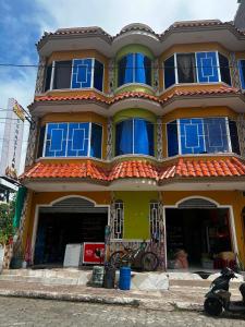 a yellow and blue house with blue windows at CASA Sebastián in Puerto Baquerizo Moreno