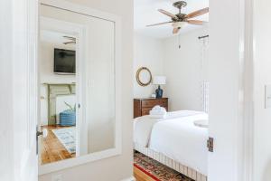 a white bedroom with a bed and a ceiling fan at Red Bud Suite in Staunton