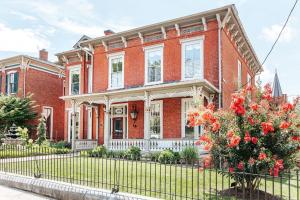 a red brick house with a fence in front of it at Red Bud Suite in Staunton